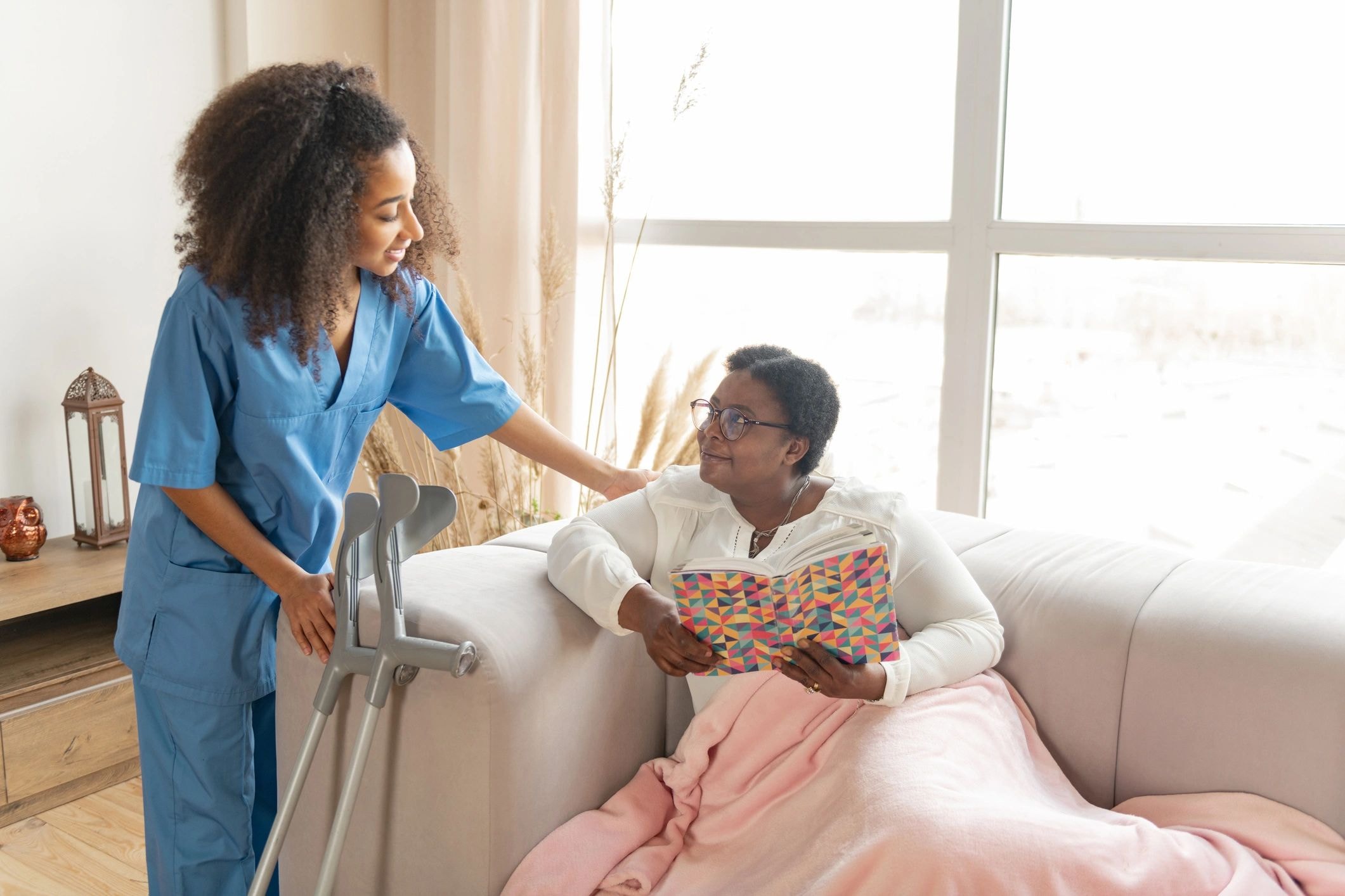 Caregiver assisting elderly client indoors